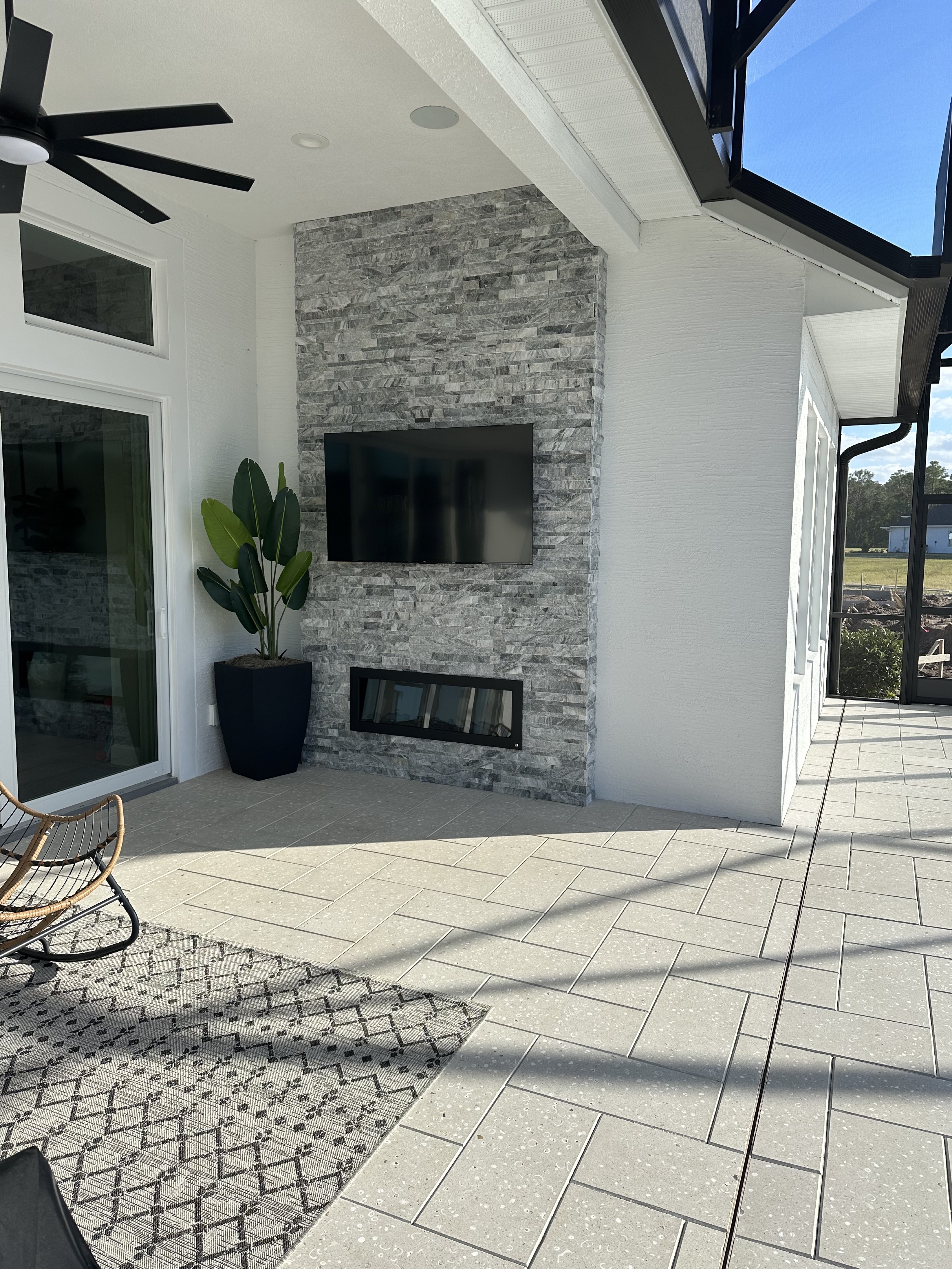 Outdoor TV wall with stone fireplace surround