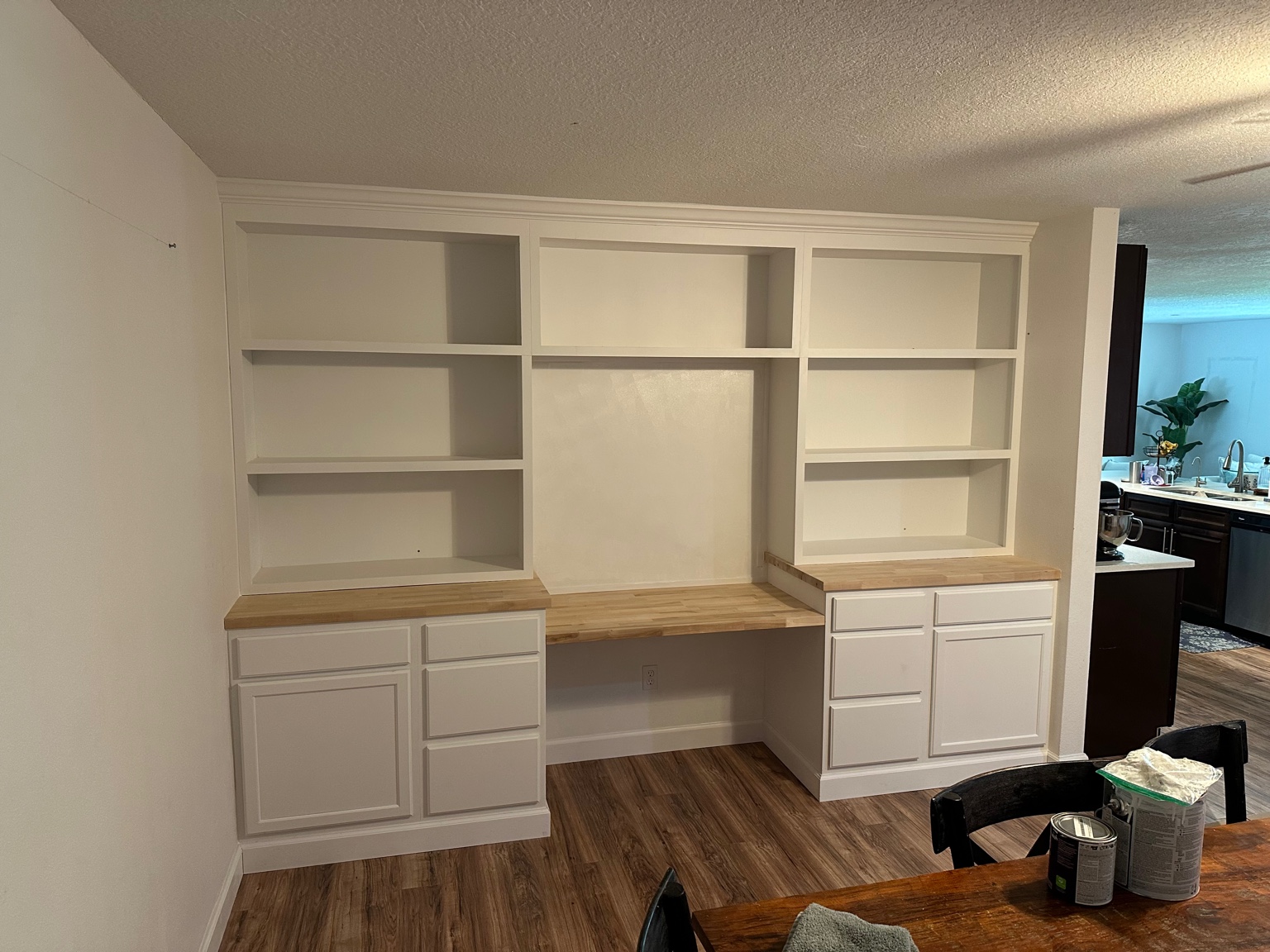 White built-in cabinetry with wood countertop and shelving